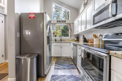a kitchen with a stainless steel refrigerator at Halonas Cozy Cabin 2M To Lake in Shaver Lake