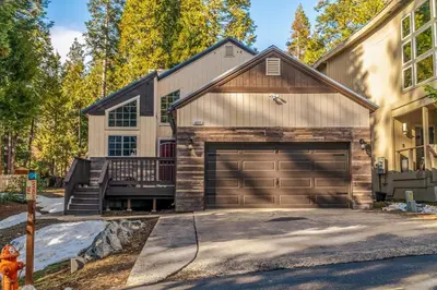a house with a garage and a fire hydrant at Halonas Cozy Cabin 2M To Lake in Shaver Lake