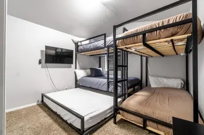 two bunk beds in a room with a tv at Halonas Cozy Cabin 2M To Lake in Shaver Lake
