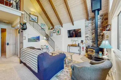 a living room with two chairs and a stone wall at Dog-Friendly Retreat with Lake Views in Kings Beach in Kings Beach