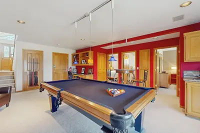 a pool table in a living room with red walls at Waterfront Bliss in South Lake Tahoe