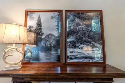 a table with a picture on the wall next to a lamp at The Trailhead Hot Tub, Hikes & Night Skies in Shaver Lake