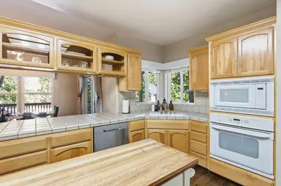 a kitchen with wooden cabinets and white appliances at The Trailhead Hot Tub, Hikes & Night Skies in Shaver Lake