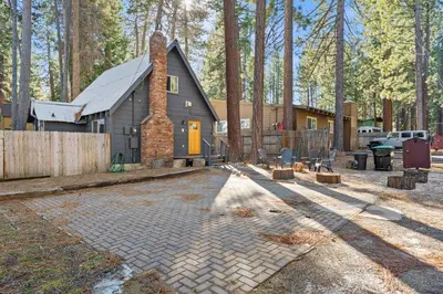 a house in the woods with a fence and a driveway at HCH0648 - Larchwood Lodge home in South Lake Tahoe