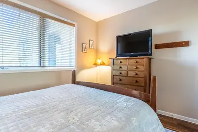 a bedroom with a bed and a flat screen tv at Mammoth Green #220 - Nearly Ski-In Ski-Out 3 Bedroom 2 Bath, Sleeps 8 in Mammoth Lakes