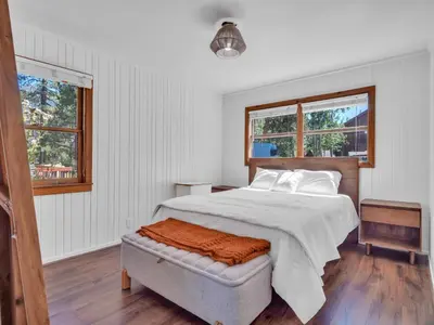 a white bedroom with a bed and two windows at Tahoe Classic Cabin Near the Beach in South Lake Tahoe