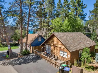 a log home with a porch and a blue house at Tahoe Classic Cabin Near the Beach in South Lake Tahoe