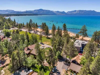 an aerial view of a resort with a beach and trees at Tahoe Classic Cabin Near the Beach in South Lake Tahoe