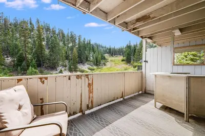 a balcony with a chair and a view of a forest at Quaking Aspen Condo in Stateline