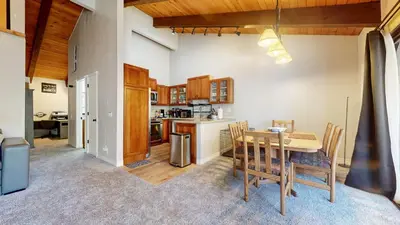 a kitchen and dining room with a table and chairs at Chateau Blanc #2 condo in Mammoth Lakes