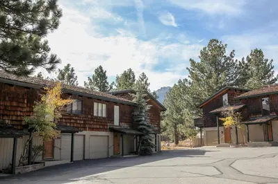 an empty driveway in front of two log homes at Chateau Blanc #2 condo in Mammoth Lakes