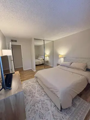 a bedroom with a large white bed and a television at Near Lake, Golf and Tennis - Reno Condo in Reno
