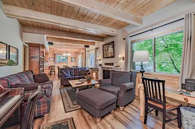 a living room filled with furniture and a piano at Lake Tahoe West Shore Lake Front 5 bedroom Cabin in Homewood