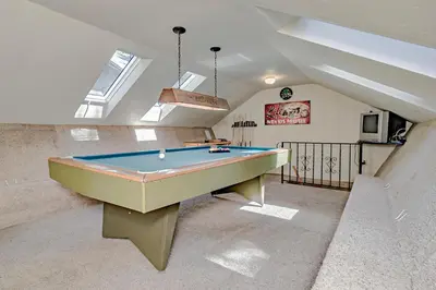 a pool table in a living room with skylights at Lake Tahoe West Shore Lake Front 5 bedroom Cabin in Homewood