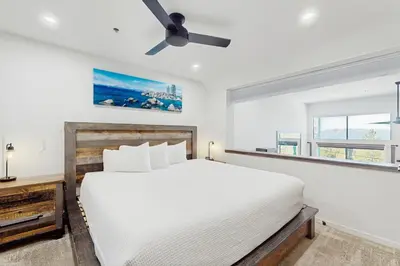 a bedroom with a white bed and a ceiling fan at Lakeview Landing in Stateline