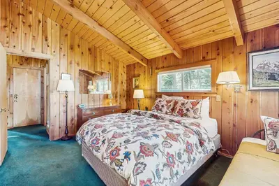 a bedroom with a bed in a room with wooden walls at Tahoe Getaway in Homewood