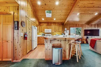 a kitchen with wooden walls and a kitchen island in a cabin at Tahoe Getaway in Homewood