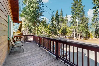 a wooden balcony with a chair on a house at Tahoe Getaway in Homewood