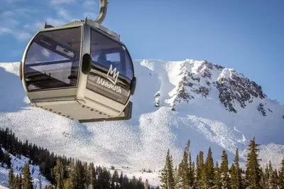 a ski lift with a snow covered mountain in the background at Snowcreek 51 in Mammoth Lakes
