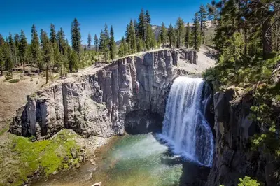 a waterfall on the side of a mountain with trees at Sierra Megeve 31 in Mammoth Lakes