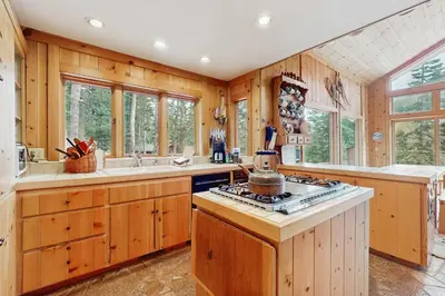 a kitchen with wooden cabinets and a stove at Bear Creek Pond Chalet in Alpine Meadows