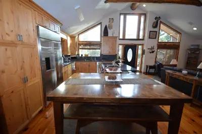 a kitchen with a wooden table and a refrigerator at Owens Den- Lake AreaFree Night Special in Bass Lake
