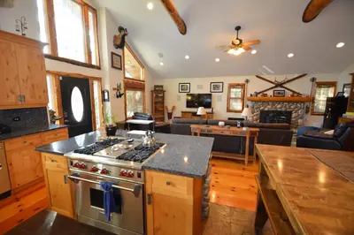 a kitchen with a stove and a living room at Owens Den- Lake AreaFree Night Special in Bass Lake