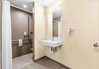 a bathroom with a sink and a shower at Aurora Inn in Modesto