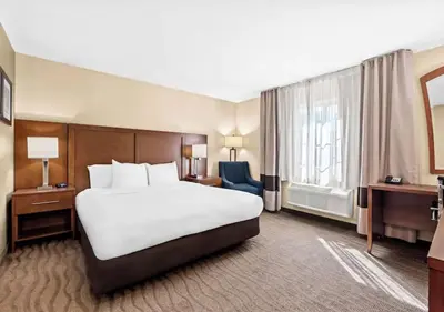 a hotel room with a large bed and a window at Aurora Inn in Modesto
