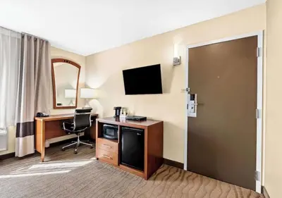 a hotel room with a desk and a television at Aurora Inn in Modesto