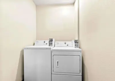 two washers and a refrigerator in a room at Aurora Inn in Modesto