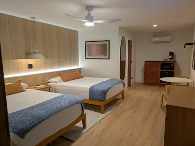 a hotel room with two beds and a kitchen at The Iceberg Tahoe in South Lake Tahoe
