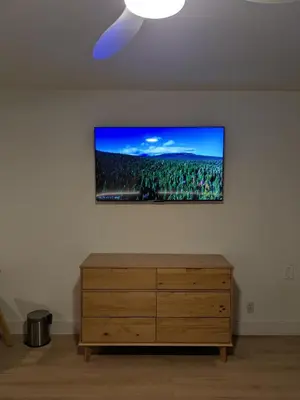 a living room with a dresser and a tv on the wall at The Iceberg Tahoe in South Lake Tahoe