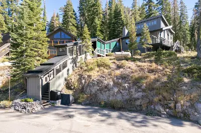 a house on top of a hill with trees at Panoramic Peaks at Alpine by Tahoe Getaways - Pet Friendly, AC, Hot Tub, Shuttle & Stunning Views in Alpine Meadows