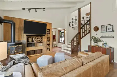 a living room with a couch and a television at Panoramic Peaks at Alpine by Tahoe Getaways - Pet Friendly, AC, Hot Tub, Shuttle & Stunning Views in Alpine Meadows