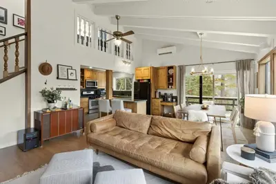 a living room with a couch and a table at Panoramic Peaks at Alpine by Tahoe Getaways - Pet Friendly, AC, Hot Tub, Shuttle & Stunning Views in Alpine Meadows