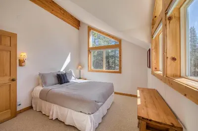 a bedroom with a bed and a wooden table at Sparrow's Rest by Tahoe Getaways - Pet-Friendly 3BR in Tahoe Donner w HOA in Truckee