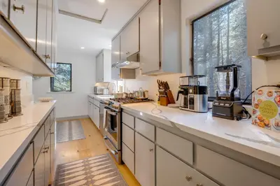 a kitchen with white cabinets and a large window at Ski-InandSki-Out Retreat with Sauna in Bear Valley! in Bear Valley
