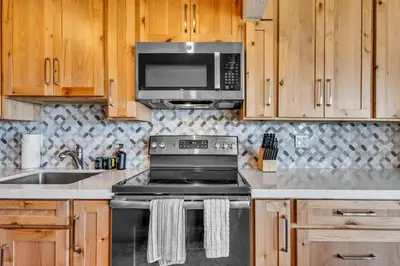 a kitchen with a stove and a microwave at Wooded Hilltop Stay Shared Hot Tub + Lake Views in Stateline