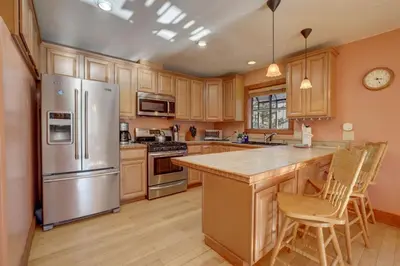 a kitchen with wooden cabinets and a stainless steel refrigerator at Knotty by Nature 3 bed home in South Lake Tahoe