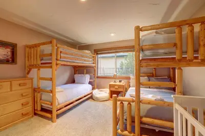 a bedroom with two bunk beds and a desk at Knotty by Nature 3 bed home in South Lake Tahoe