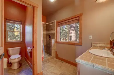 a bathroom with a toilet and a sink and a shower at Knotty by Nature 3 bed home in South Lake Tahoe