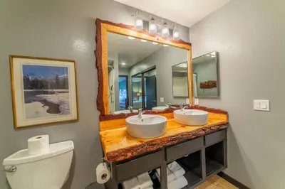 a bathroom with two sinks and a mirror and a toilet at Tranquil & Woodsy 2/2 Retreat – Jacuzzi, W/D, BBQ! in Mammoth Lakes