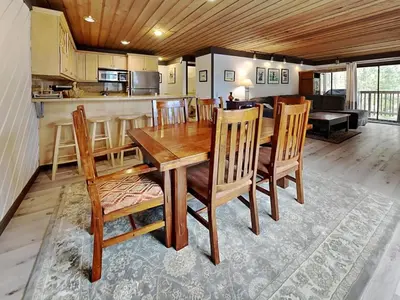a kitchen and dining room with a wooden table and chairs at Slopeside Condo With Fireplace Snowbird 112 At 1849 Condos in Mammoth Lakes