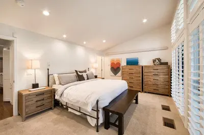 a bedroom with a large bed and wooden cabinets at Ridge Court # 13 by Tahoe Getaways - 3BR Palisades at Alpine Condo w Ski Shuttle & Tennis! in Alpine Meadows