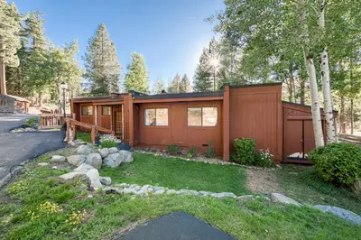 a small house in the middle of a yard at Ridge Court # 13 by Tahoe Getaways - 3BR Palisades at Alpine Condo w Ski Shuttle & Tennis! in Alpine Meadows