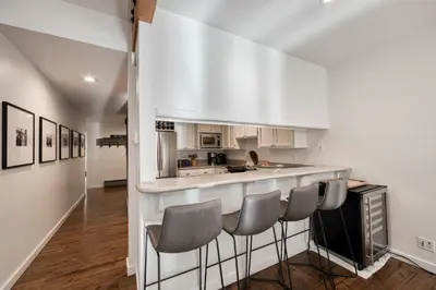 a kitchen with a bar with four chairs in it at Ridge Court # 13 by Tahoe Getaways - 3BR Palisades at Alpine Condo w Ski Shuttle & Tennis! in Alpine Meadows