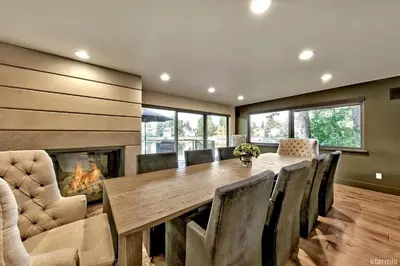 a dining room with a fireplace and a wooden table and chairs at 2030 Marconi Way home in South Lake Tahoe