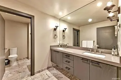 a bathroom with a sink and a toilet and a mirror at 2030 Marconi Way home in South Lake Tahoe