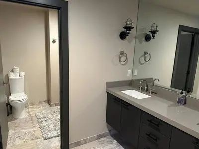 a bathroom with a toilet and a sink and a mirror at 2030 Marconi Way home in South Lake Tahoe